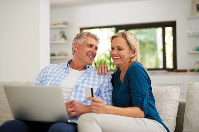 Digital-cauc-couple-midage-smiling-laptop-card